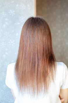 A girl with long, straight and beautiful brown hair. Hair care at home.