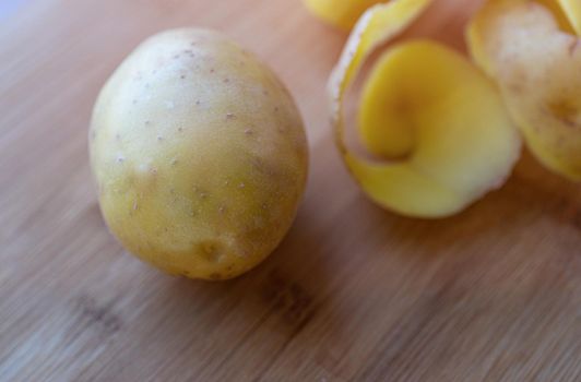 Raw potatoes with peel on a cutting Board.