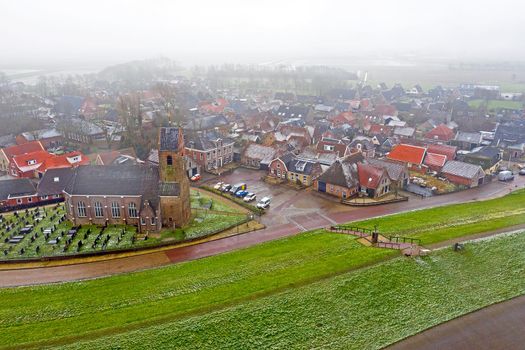Aerial from the snowy village Wierum in winter in the Netherlands near the Waddenzee