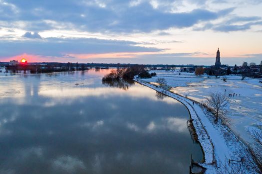 Aerial from the snowy city Rhenen in the Netherlands in winter at sunset