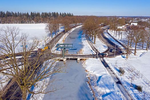 Aerial from a dutch landscape with a draw bridge in winter in the Netherlands