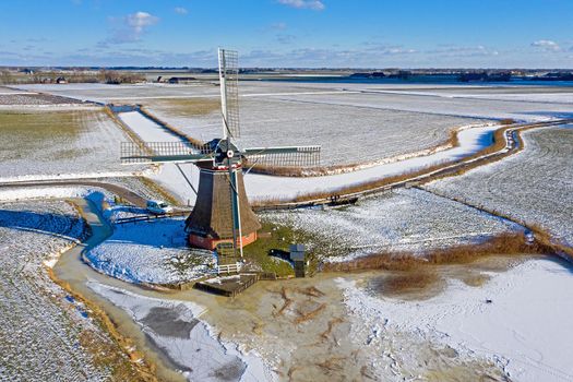 Aerial from a traditional windmill near Hantum in Friesland on a winter day in the Netherlands