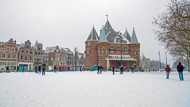 Traditional snowy Waag building at the Nieuwmarkt in Amsterdam in the Netherlands in winter