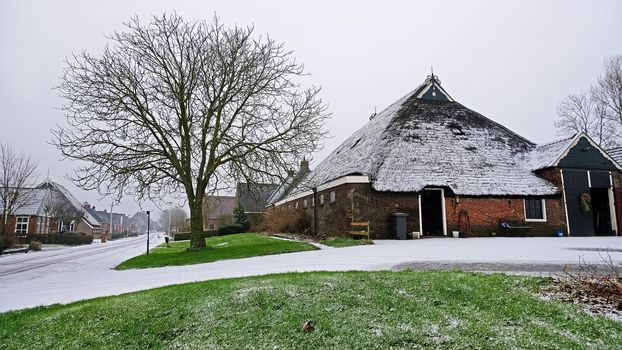 Traditional snowy farm house in winter in the countryside from the Netherlands 