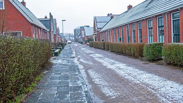 Traditional old snowy dutch street in winter in the Netherlands