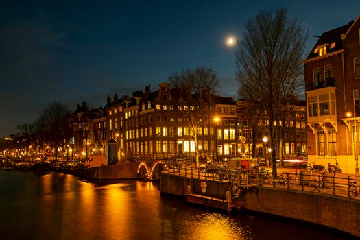 Traditional Amsterdam houses at the river Amstel in the Netherlands at night