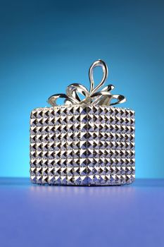 A silver gift box over a blue background.