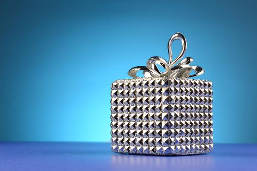 A silver gift box over a blue background.
