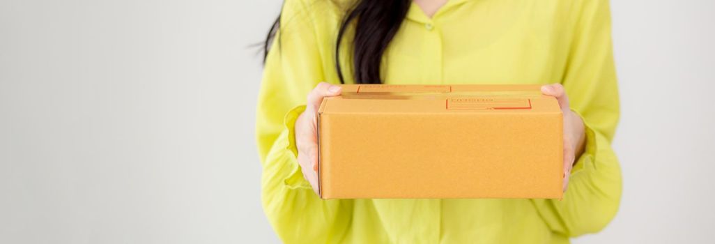 Young asian woman holding cardboard box at home, happy female carrying parcel box giving, present and gift, packaging for deliver, online shopping store and service concept.