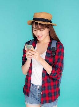 Beautiful young asian woman touch smart mobile phone in vacation isolated on blue background, asia girl talking or chat message on smartphone in travel summer trip, journey or education concept.