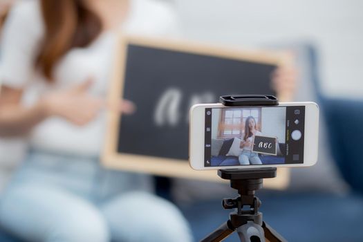 Young asian woman is teacher teaching language english with student for e-learning online at home, girl working and talking lesson in class with smartphone, stay home, new normal, education concept.