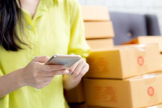 Closeup hand of young asian woman is entrepreneur check order from phone with customer while purchase online, logistic and delivery, online shopping, female is seller of business SME.