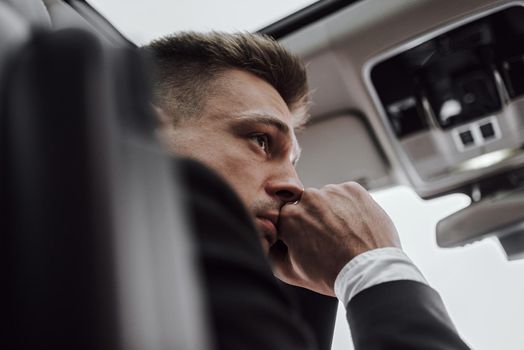 Close up of serious businessman sitting in rented automobile. Rent and trade-in concept