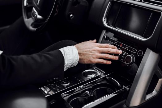 Close up of businessman using car system control. Transportation and vehicle concept