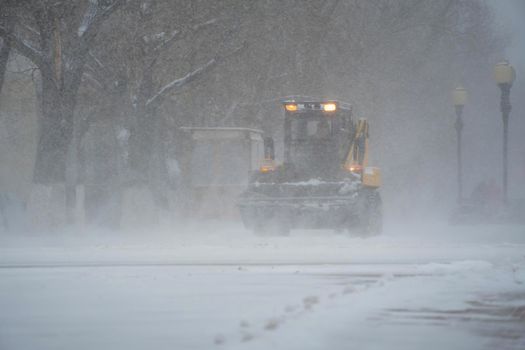 Snow removal equipment, utilities and municipal services are clearing the snow from the streets in the snow storm,Blizzard and snowstorm.Weather conditions in winter.Bad weather conditions with snow