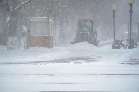 Snow removal equipment, utilities and municipal services are clearing the snow from the streets in the snow storm,Blizzard and snowstorm.Weather conditions in winter.Bad weather conditions with snow