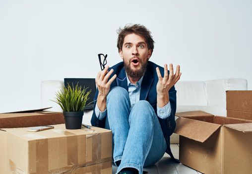 Emotional male manager unpacking lifestyle boxes in office. High quality photo