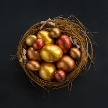 Happy Easter holiday greeting symbol stylish natural wooden grass nest with golden quail eggs on black background