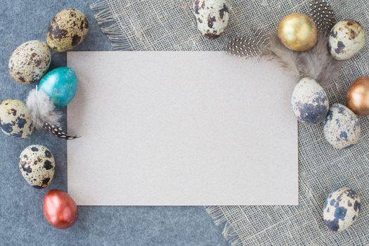 Easter greeting card with copy space for text and beautiful decor of eggs and feathers on fabric background pastel colored template for design