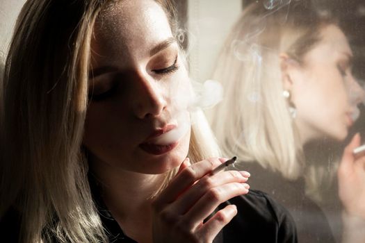 Close-Up Of Young Woman Smoking Cigarette By Window