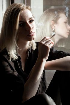 Close-Up Of Young Woman Smoking Cigarette By Window