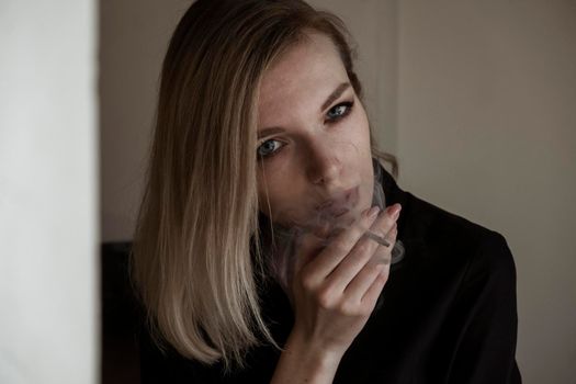 Close-Up Of Young Woman Smoking Cigarette By Window