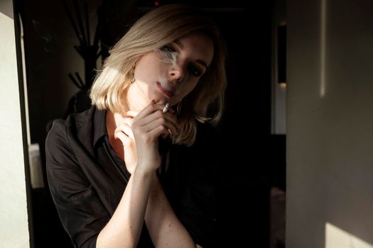 Close-Up Of Young Woman Smoking Cigarette By Window