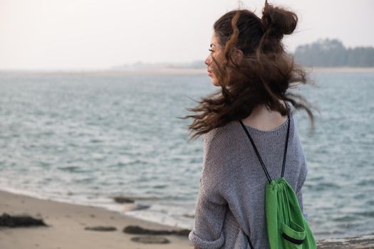 Asian woman with long windy hair looking forward