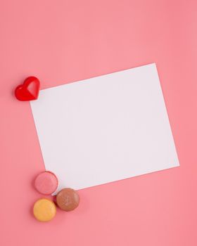 card with heart and macaroons on pink background