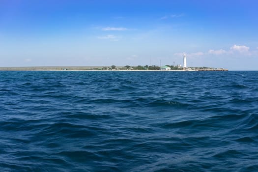 Marine landscape with views of the Cape Tarhankut and the white lighthouse against the sky. Travelling to Crimea.