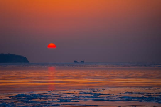 Seascape ice beach and the red sunset.