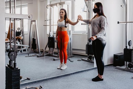 gym closed due to covid-19 virus. Woman in the reflection of a mirror in a handkerchief and during exercise.