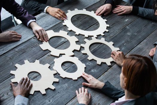 Business people connect golden gear together at meeting table, success cooperation teamwork concept