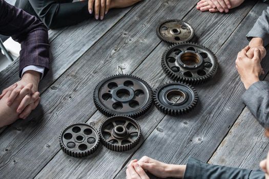 Business people connect gear together at meeting table, success cooperation teamwork concept