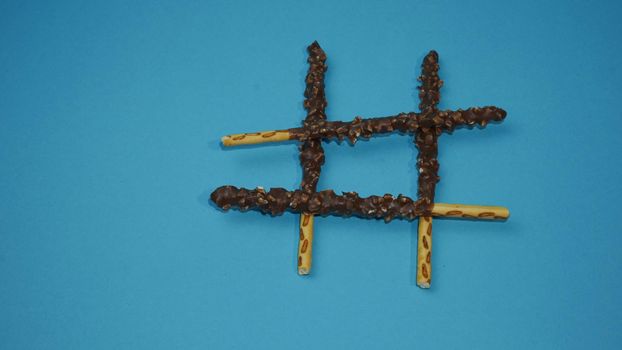 Chocolate crispy sticks with hazelnut sprinkles on a blue background.