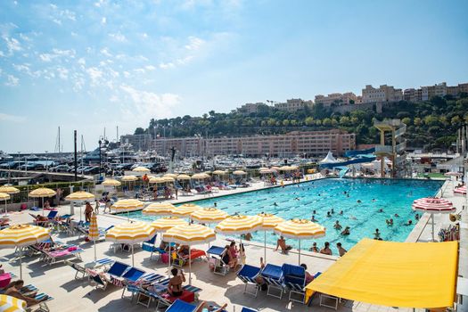Monaco, Monte-Carlo, 06 August 2018: The famous pool in port Hercules, is the parked boats, a lot of people, Children and elderly people, many yachts and boats, Prince's Palace, megayachts