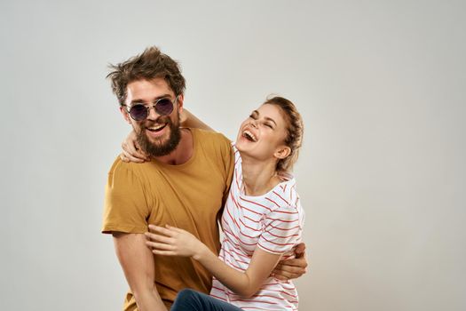 man in sunglasses next to woman in striped t-shirt emotions communication fashion studio fun. High quality photo