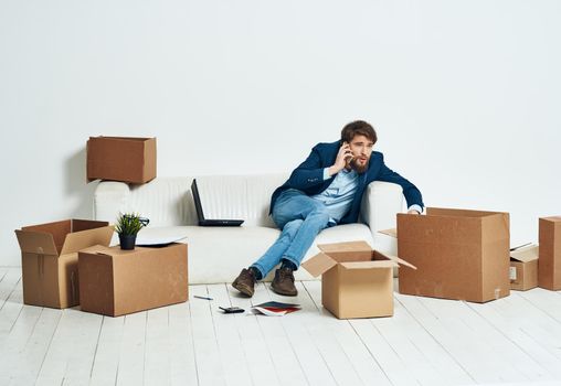 a man sitting on the couch talking on the phone an official box of things. High quality photo