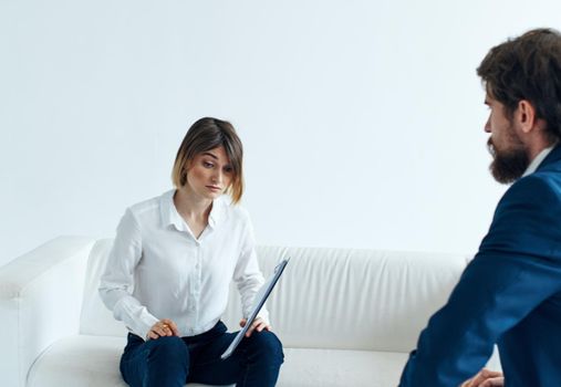 Business man in a classic suit and a woman on the couch with documents in the hands of a psychologist . High quality photo