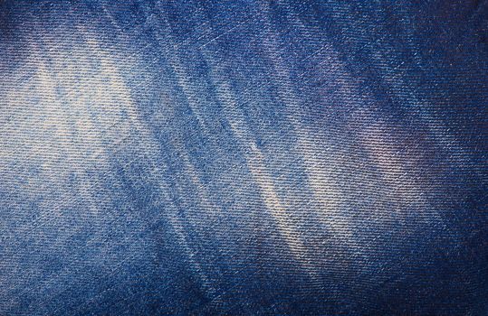 Texture of blue jeans background, ripped jeans.