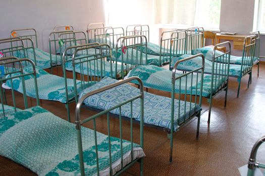 Interior of an old Russian kindergarten with iron beds.