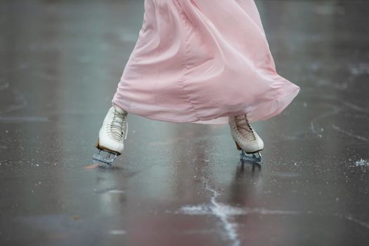 Legs of skater on winter ice rink in outdoors