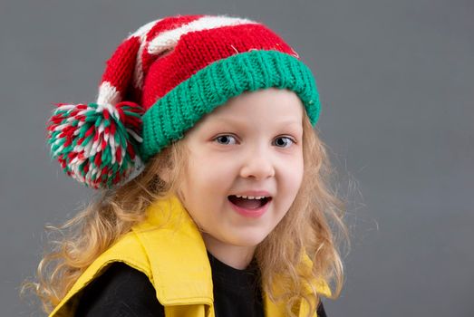 Funny little girl in a Christmas hat. Portrait of a cheerful and happy child.