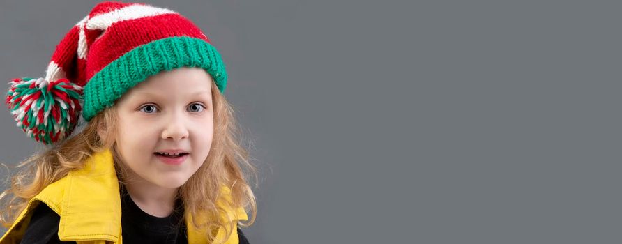 Funny little girl in a Christmas hat. Portrait of a cheerful and happy child.