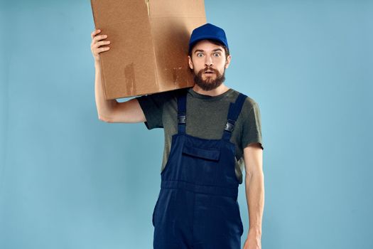 Man in working uniform loading service and delivery blue background. High quality photo