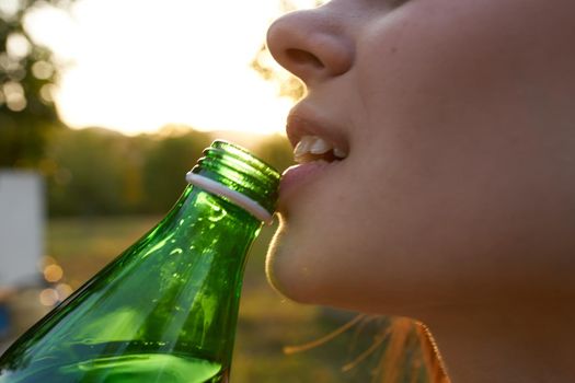 happy woman with bottle of water for invitation in garden close-up cropped view. High quality photo