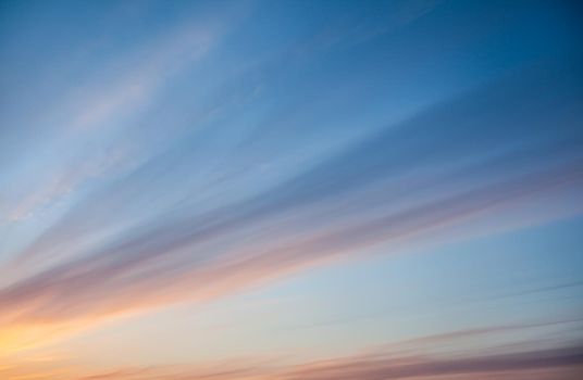 Colorful sunset or sunrise in the sky. The sky and clouds are painted in different delicate colors.