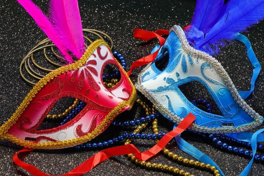 Mardi Gras carnival theme parade face masks with feathers and jewelry on textured black