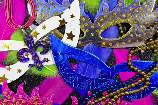 Mardi Gras carnival theme parade flat face masks with feathers and jewelry layout on textured black