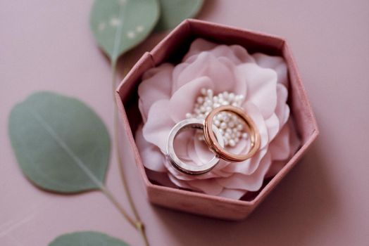 wedding rings with a wedding pink box and green decor